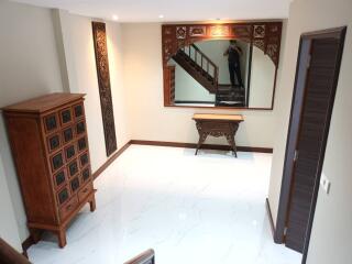 A well-lit and decorated living room with wooden furniture and white tiled floor