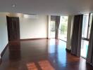 Spacious living room with wooden flooring and large windows