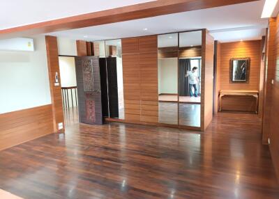 Spacious living area with wooden flooring and mirrored closet