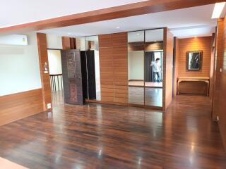 Spacious living area with wooden flooring and mirrored closet