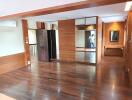 Spacious living area with wooden flooring and mirrored closet