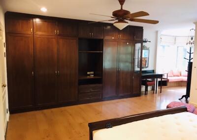 Spacious bedroom with wooden wardrobe and ceiling fan