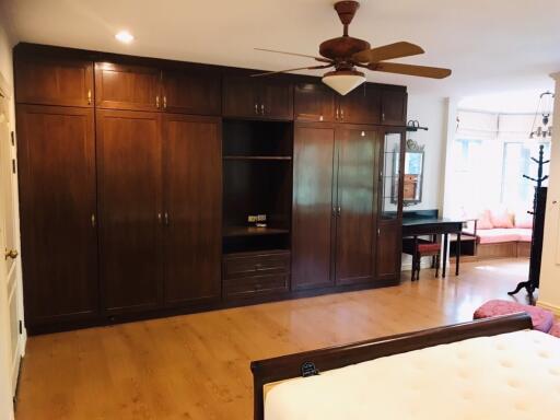 Spacious bedroom with wooden wardrobe and ceiling fan