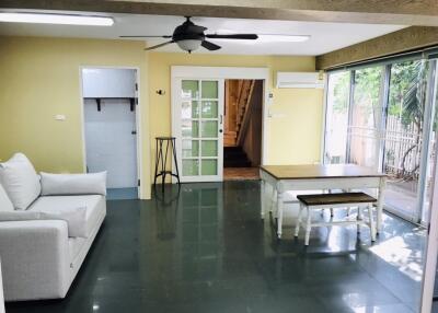 Modern living area with sofa, table, and ceiling fan