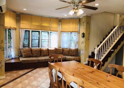 Bright main living area with wooden dining table and large window seat