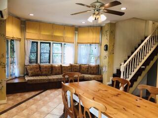 Bright main living area with wooden dining table and large window seat