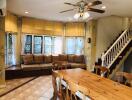 Bright main living area with wooden dining table and large window seat