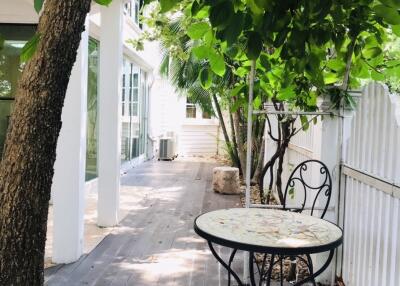 Outdoor seating area with table and chairs under trees