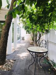 Outdoor seating area with table and chairs under trees