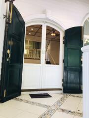 Front door with intricate double doors and tiled entrance