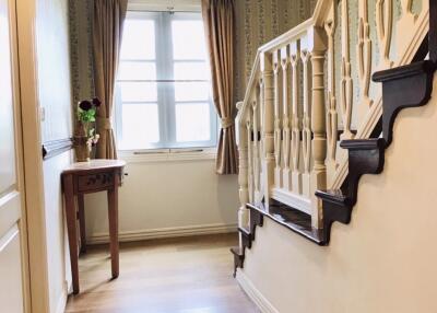 Bright hallway with wooden staircase.