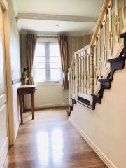 Bright hallway with wooden staircase.