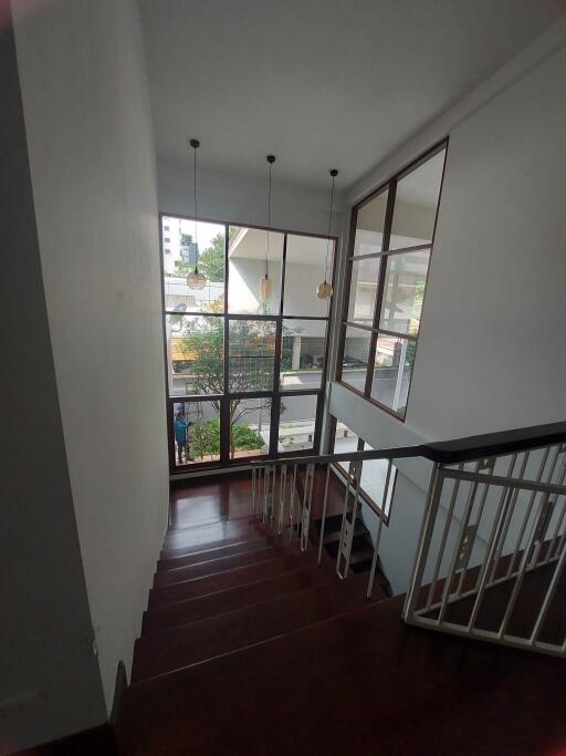 Bright staircase with large windows and pendant lights