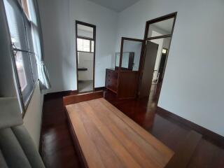 Unfurnished bedroom with wooden flooring and an open window