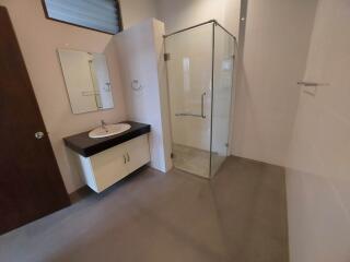 Modern bathroom with glass shower, vanity, and mirror