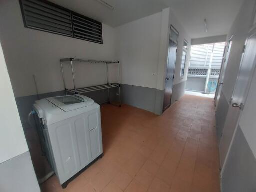 Utility room with a washing machine and storage rack