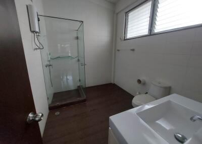 Modern bathroom with glass shower, sink, and toilet