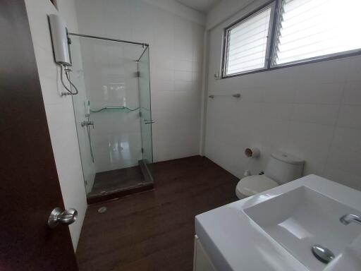 Modern bathroom with glass shower, sink, and toilet