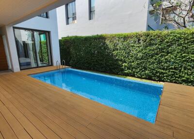 Modern outdoor pool area with wooden deck