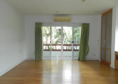 Spacious living area with large windows and balcony view