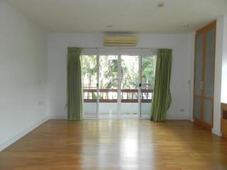 Spacious living area with large windows and balcony view