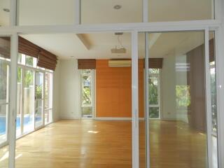 Spacious living room with large windows and wooden floor