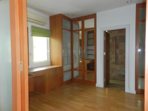 Bedroom with wooden flooring and built-in wooden wardrobes