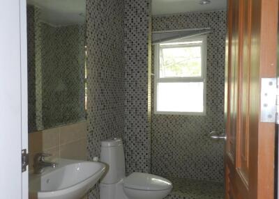 Modern bathroom with sink, toilet, and tiled walls