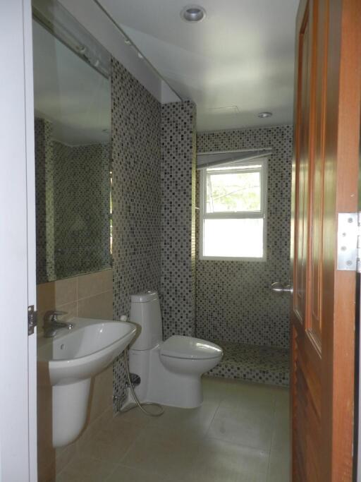 Modern bathroom with sink, toilet, and tiled walls