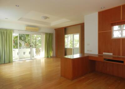 Spacious living room with wooden flooring and large windows.