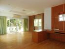 Spacious living room with wooden flooring and large windows.