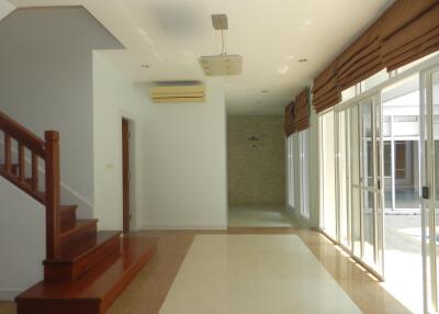 Spacious living room with large windows and staircase