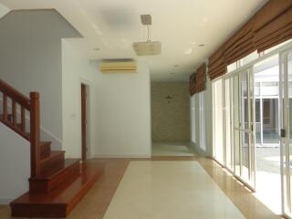 Spacious living room with large windows and staircase