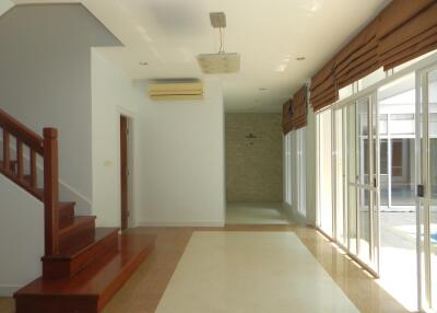 Spacious living room with staircase and large windows