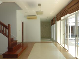 Spacious living room with staircase and large windows