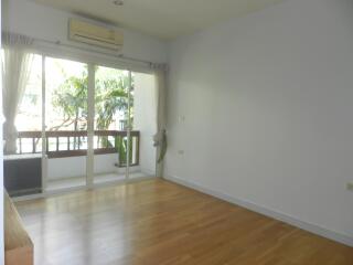 Spacious living room with wooden floor and large window