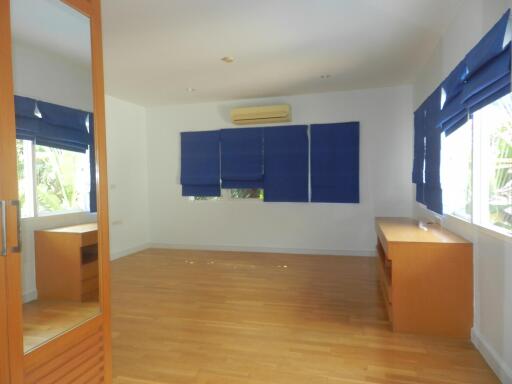 empty bedroom with wooden floor and blue blinds