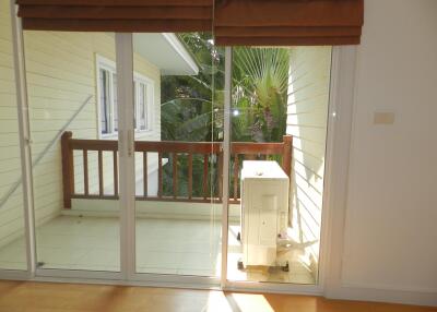 Balcony with glass doors and view of foliage