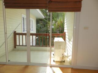 Balcony with glass doors and view of foliage