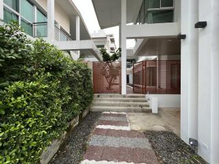 Modern exterior view with garden path and wooden privacy screen