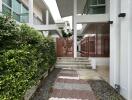 Modern exterior view with garden path and wooden privacy screen