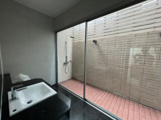 Modern bathroom with large window and exterior shower