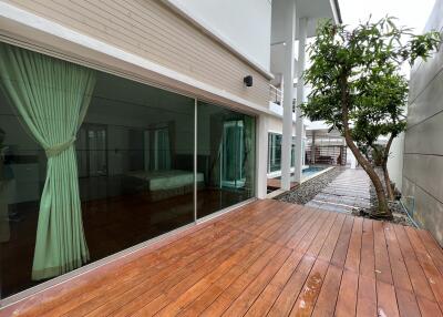 Exterior view of a modern house with sliding glass doors and adjacent swimming pool