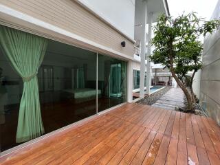 Exterior view of a modern house with sliding glass doors and adjacent swimming pool