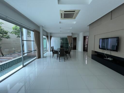 Spacious and modern living room with large windows and dining area.