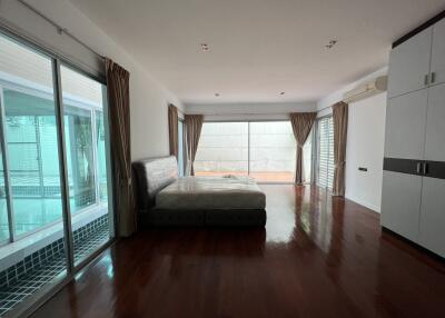 Spacious bedroom with large windows and hardwood floor