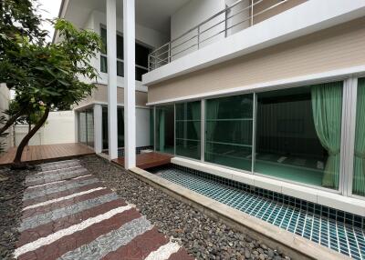 Modern house exterior with large windows and a garden pathway