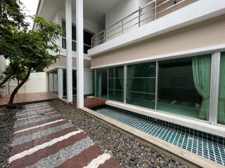 Modern house exterior with large windows and a garden pathway