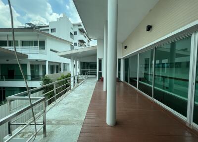 Spacious balcony area with modern glass doors and view of surrounding buildings