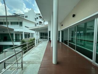 Spacious balcony area with modern glass doors and view of surrounding buildings